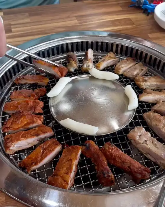 숯불 위에서 익어가는 닭갈비와 떡, 마늘
