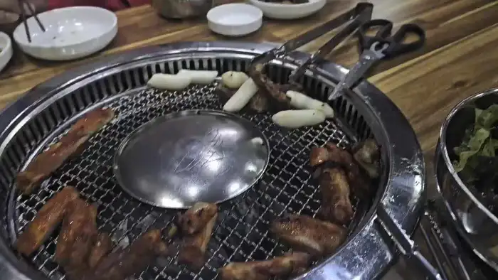 숯불 위에서 익어가는 닭갈비와 막국수