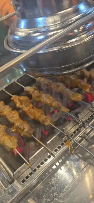 양꼬치 꼬치들이 숯불 위에서 구워지는 모습