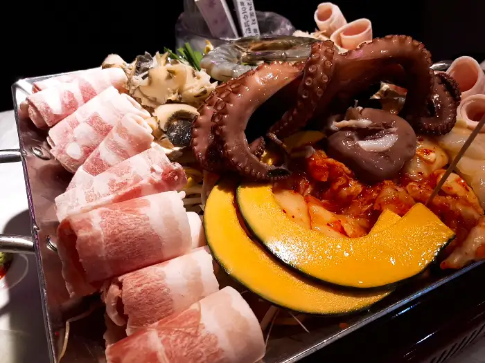 다양한 해산물과 삼겹살, 채소가 푸짐하게 담긴 철판 요리