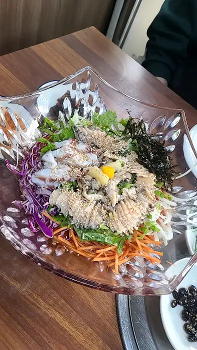 여러 가지 잎채소와 해산물, 붉은 양배추 채가 어우러진 샐러드