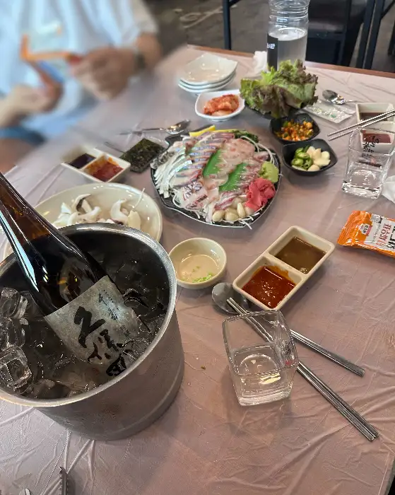 술병과 함께 놓인 회 접시