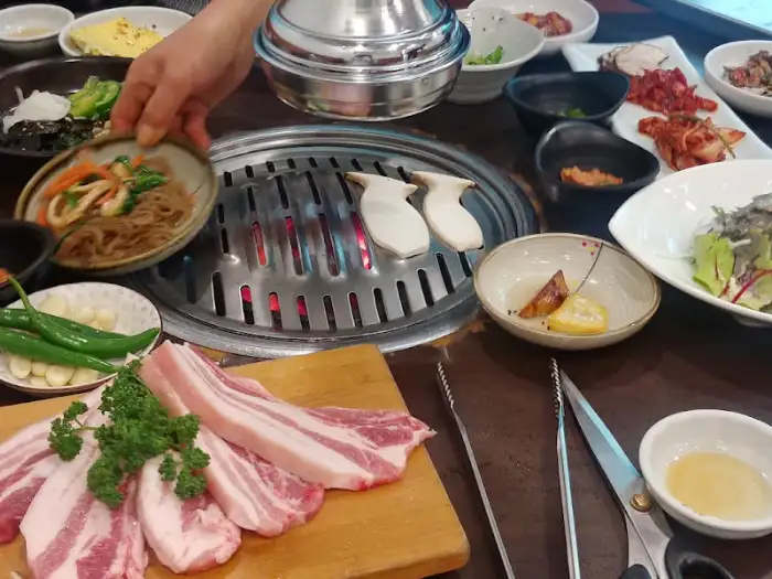 신선한 삼겹살과 쌈 채소가 준비된 식탁