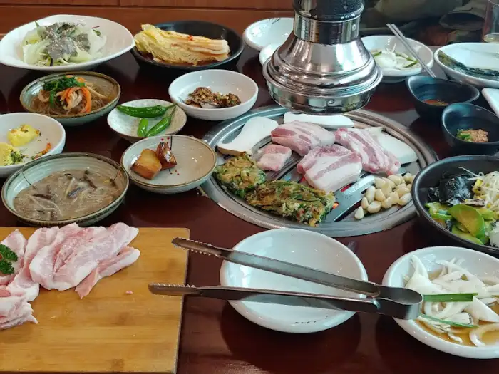 그릴 위에서 구워지는 돼지고기와 곁들임 반찬