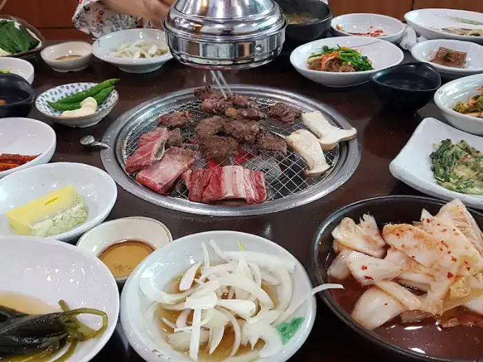 노릇하게 구워지는 돼지고기와 곁들임 채소, 양파 슬라이스