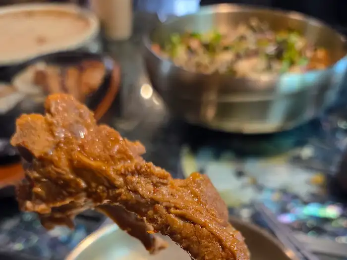 집게로 집어 올린 부드러운 등갈비살