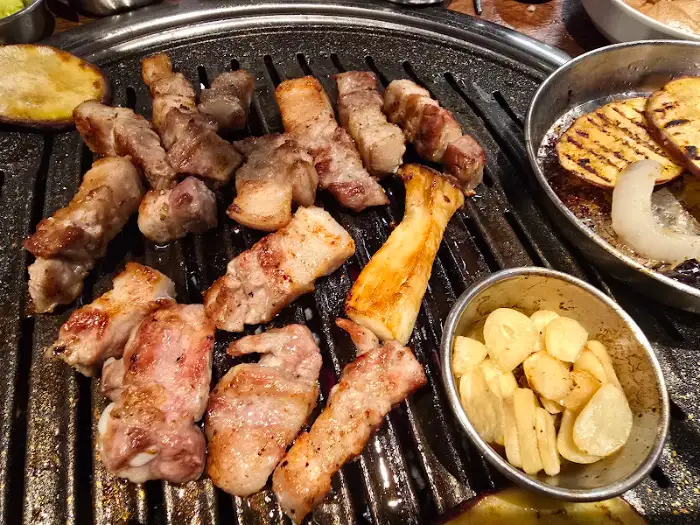 잘 구워진 삼겹살과 목살, 곁들임 채소, 마늘구이