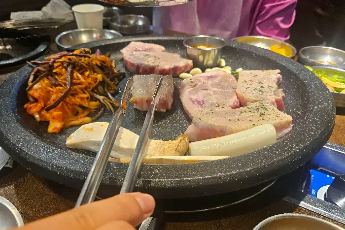 다양한 고기 및 곁들임 메뉴가 올려진 불판