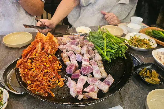 솥뚜껑 위에 가득 차려진 푸짐한 삼겹살 한상