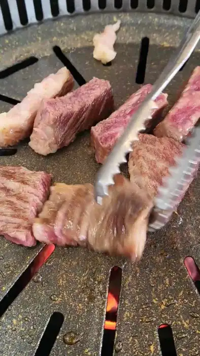 집게로 한우 조각을 집어 옮기는 모습