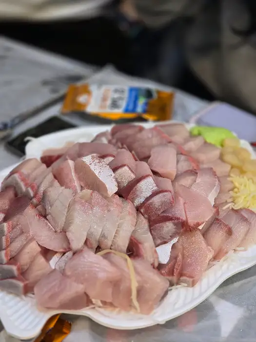 접시에 가득 담긴 다양한 종류의 횟감. 두툼한 두께와 신선한 색감이 돋보인다.