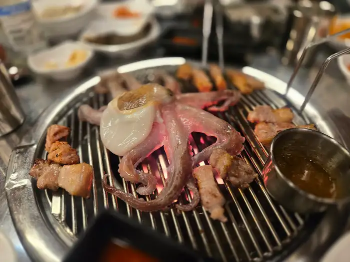 불판 위에서 구워지고 있는 흑돼지와 문어