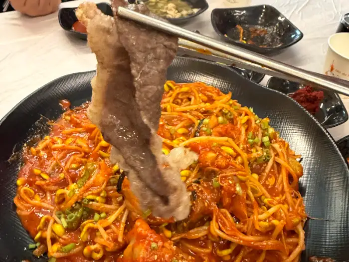 차돌박이로 아구찜을 싸먹는 모습