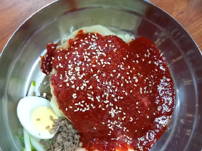 달걀 반쪽과 다진 고기가 보이는 언양밀면