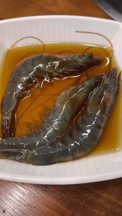 간장 양념에 담긴 두 마리의 신선한 새우