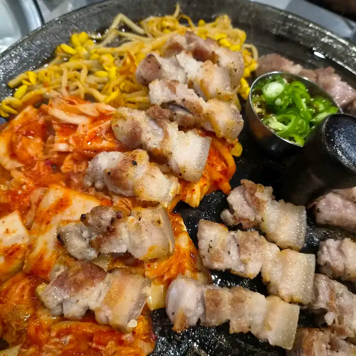 목구멍 부산 구서점의 먹음직스러운 삼겹살과 곁들임 메뉴