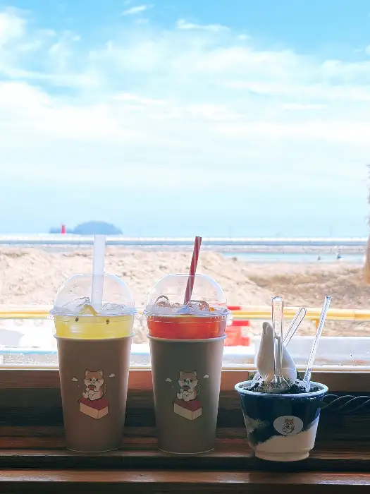 바다를 배경으로 놓인 두 잔의 음료와 아이스크림