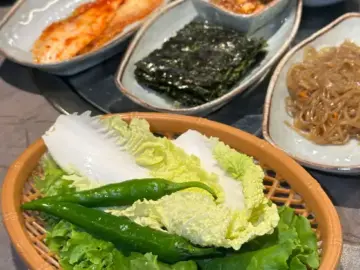 다양한 밑반찬과 신선한 채소가 차려진 한우일번지X규이치 식사 상차림