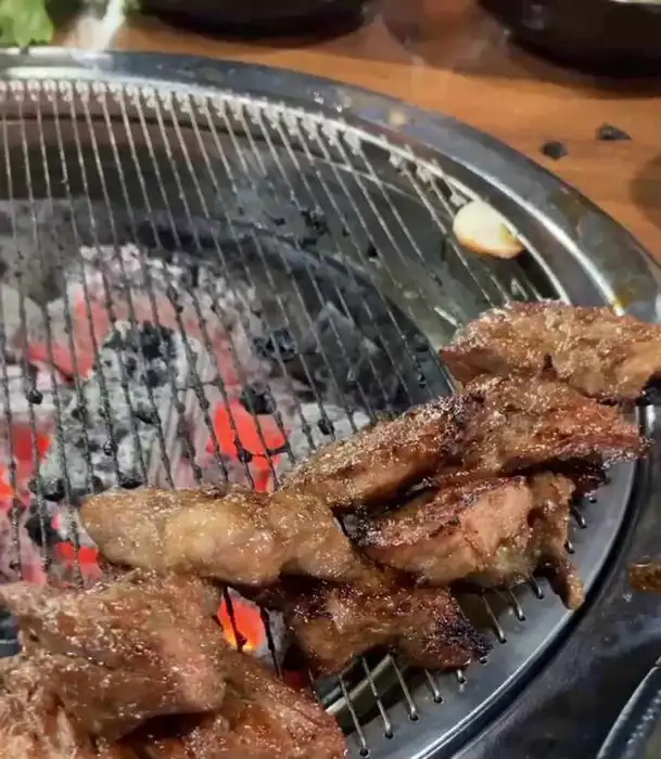 잘 구워진 갈비 한 점을 집는 집게