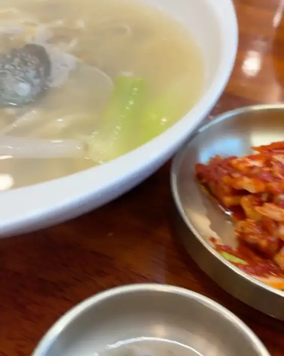 따뜻한 국물의 칼국수와 곁들여 나온 김치의 모습