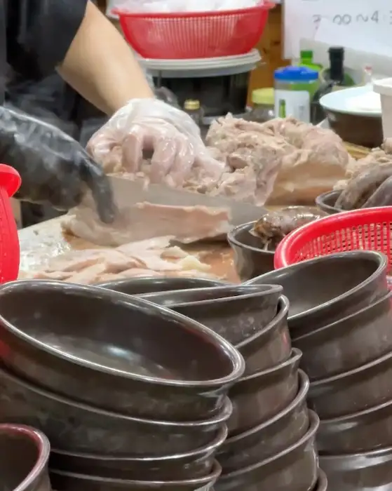 신송자 신마산식당 주방에서 고기를 썰고 있는 모습