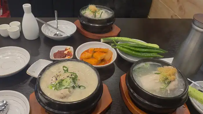 경복궁삼계탕 동대문점의 테이블 세팅 모습. 삼계탕, 깍두기, 고추, 소스 등이 정갈하게 담겨 있다.