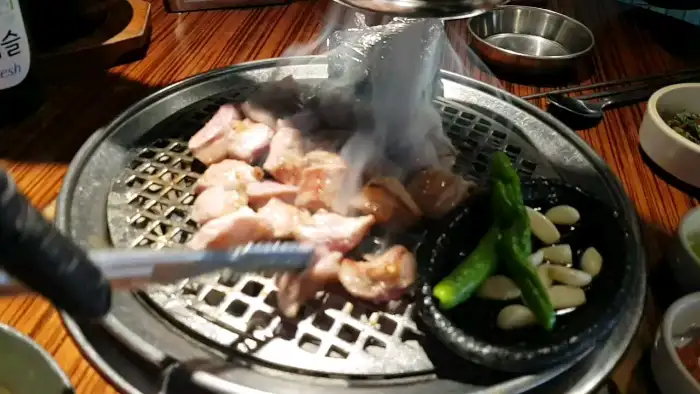 숯불 위에서 맛있게 익어가는 삼겹살과 가브리살